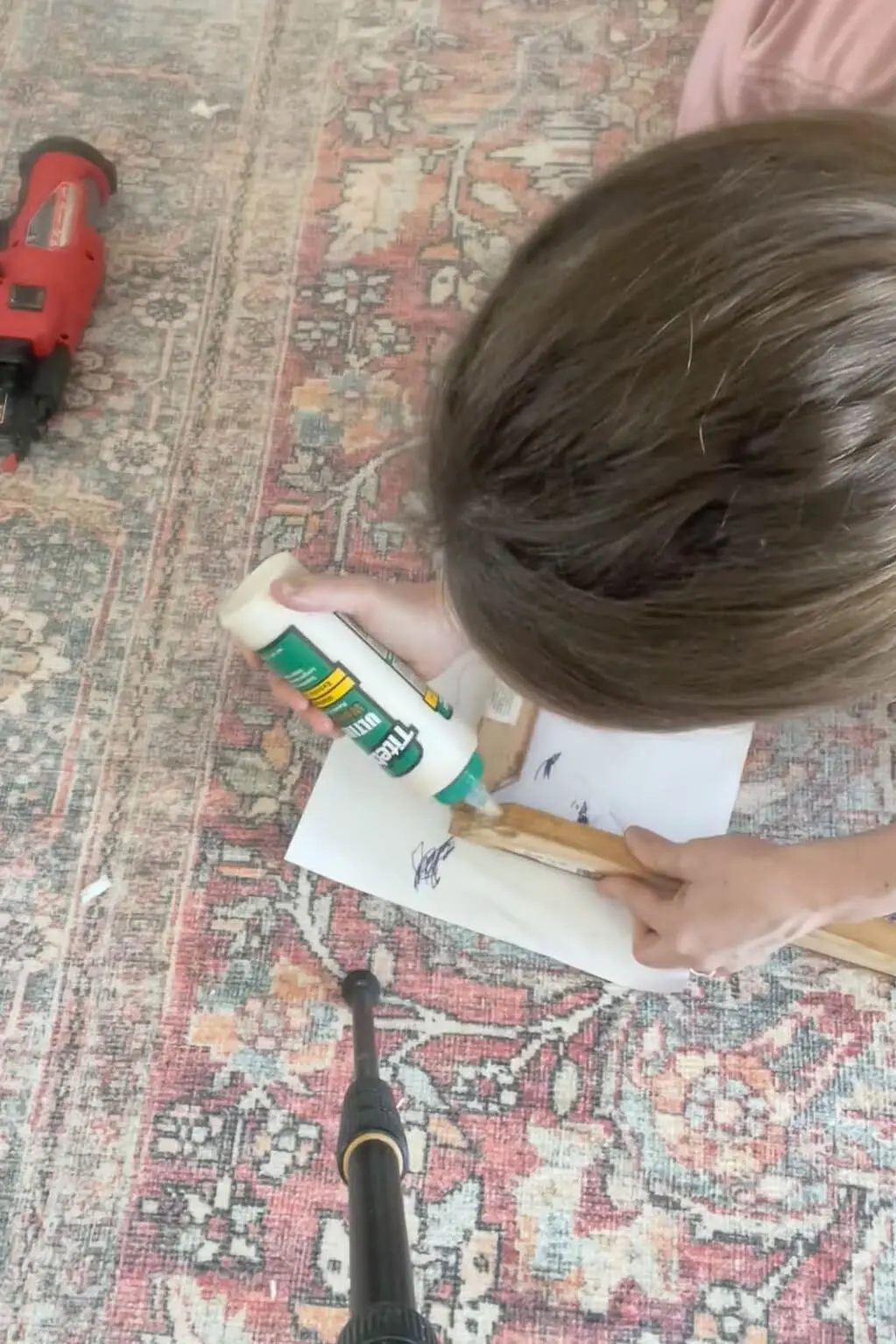 Using wood glue to assemble a DIY bathroom mirror frame.